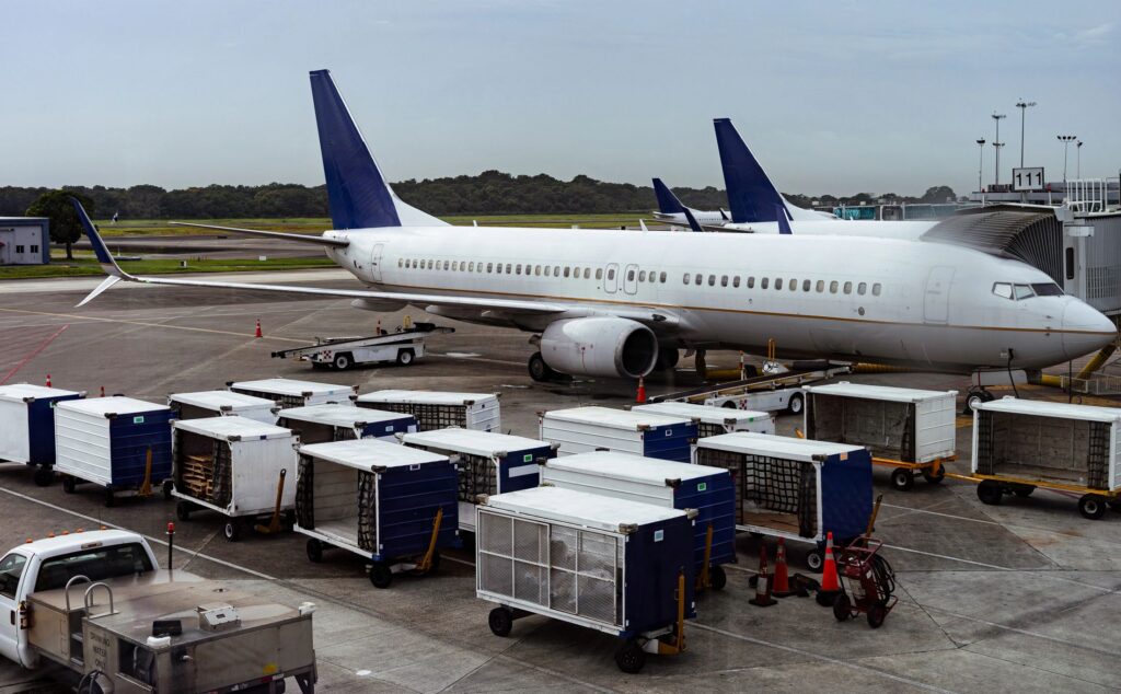 Airplane at airport gate with cargo containers